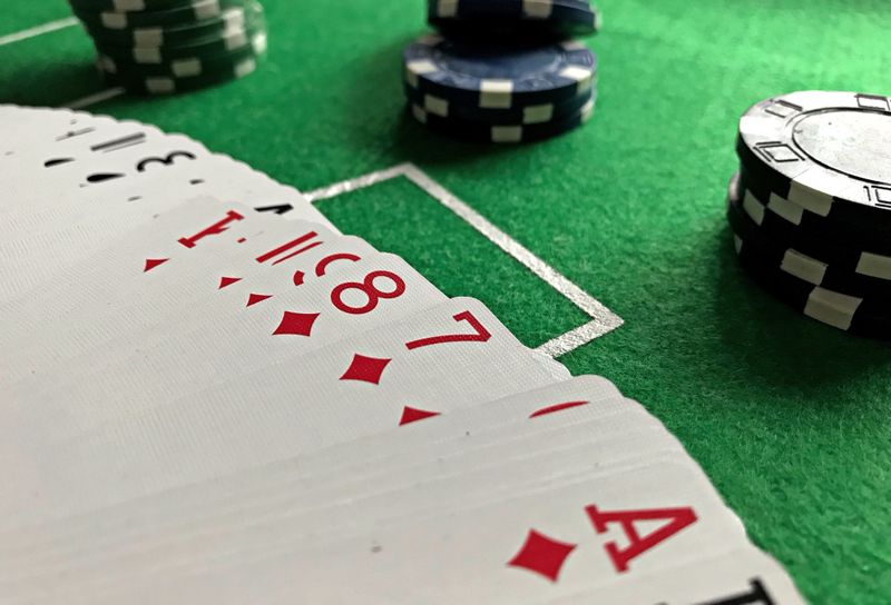 Setumpuk kartu remi dan chip poker di atas meja